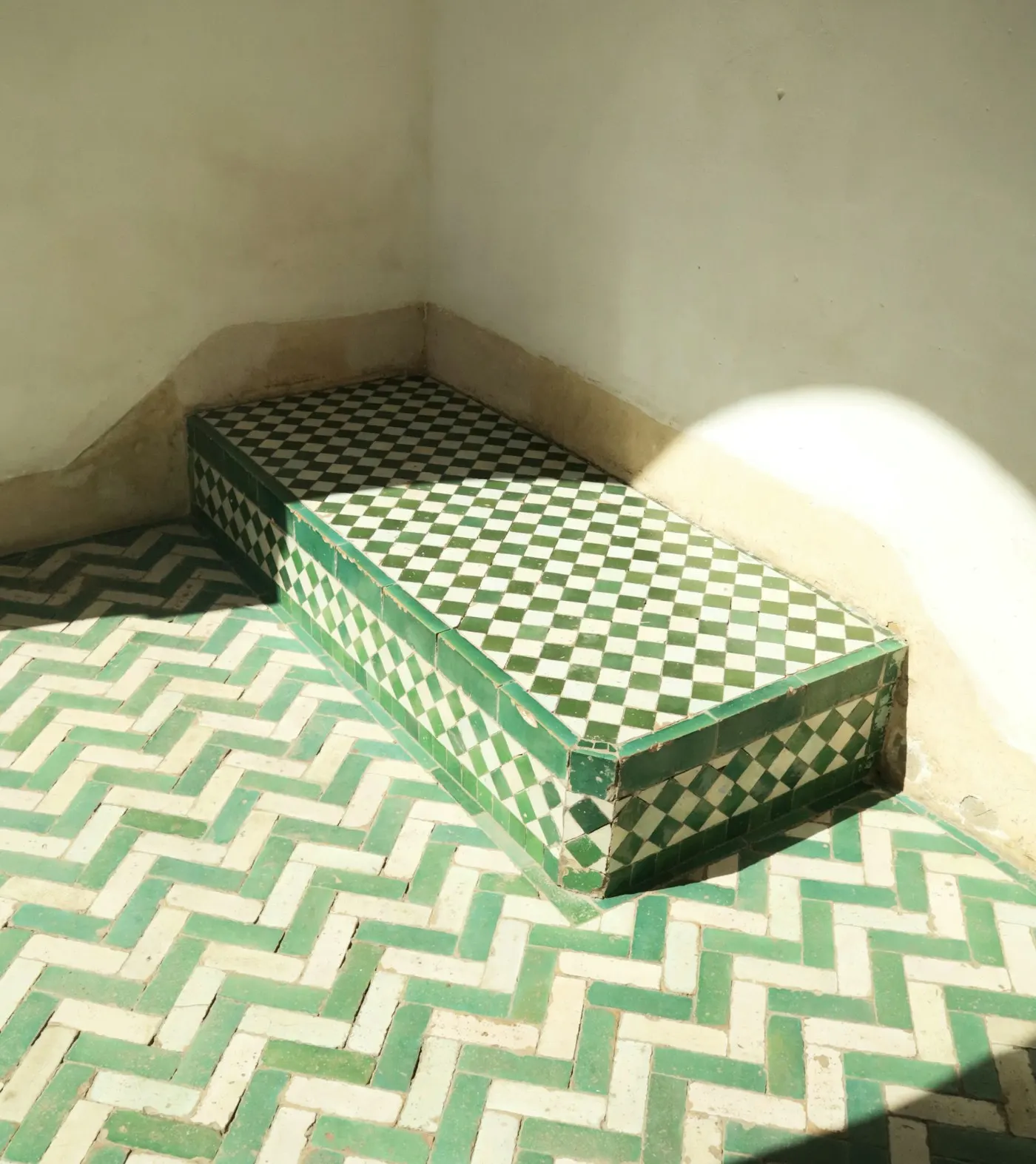 Green and white zellige tile on a bench and chevron floor